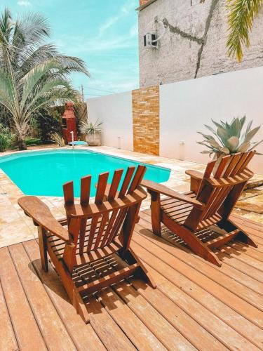 普雷亚Villa Fortal Preá的两把木椅坐在游泳池旁的甲板上