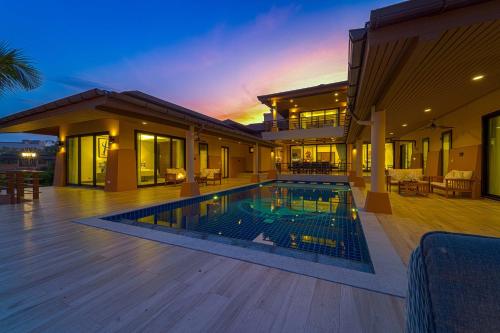 华欣Luxury 5 Bedroom Villa Close to Beach SRS的房屋前有游泳池的房子