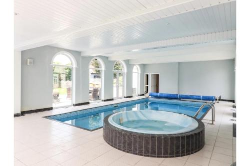 Canvey IslandLuxurious 6 Bedroom Villa with Pool Sleeps 12的一个带大浴缸的大型游泳池