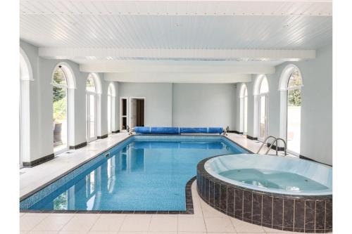 Canvey IslandLuxurious 6 Bedroom Villa with Pool Sleeps 12的一座大楼内带热水浴池的游泳池