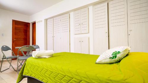 ChepesBambú Hotel的一间卧室配有绿色的床和椅子