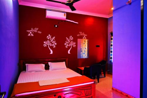 KottakupamAuro Galaxy Pondy with Swimming Pool的一间卧室配有一张红色和紫色灯床