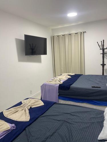 阿拉亚尔-杜卡布Golden Lake Apart Hotel Arraial do Cabo的一间卧室配有两张床和一台平面电视