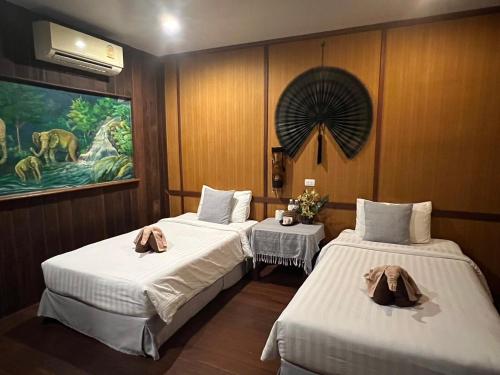 班泰V景观海滩度假酒店的一间设有两张床的客房,墙上挂着一幅画