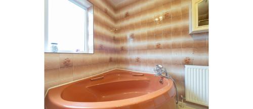 HadleighCasual and Cozy 5 BD Home in Canvey Island的带窗户的浴室内的红色浴缸