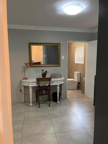 鲁德普特Hill Luxury Cottage的浴室设有白色的办公桌和镜子。