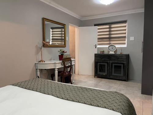 鲁德普特Hill Luxury Cottage的一间卧室配有一张床、一个水槽和一张书桌