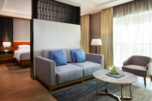 万隆Courtyard by Marriott Bandung Dago的客厅配有沙发和1张床