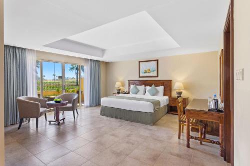 拉斯阿尔卡麦Al Hamra Village Hotel的配有一张床和一张书桌的酒店客房
