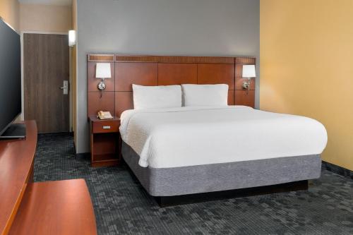 俄克拉何马城俄克拉荷马城机场万怡酒店的一间卧室配有一张大床和电视