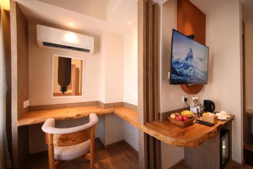 加德满都Daali Hotel & Apartment的客房设有书桌、电视和椅子