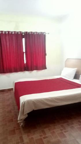 科代卡纳尔FLGHR Green Residency的一间卧室配有一张带红色窗帘的大床