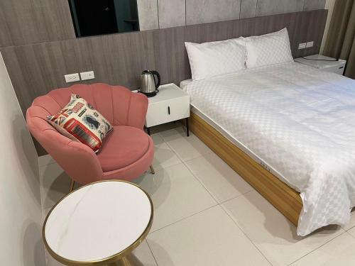 台东孟鍹民宿的一间卧室配有红色椅子和一张床