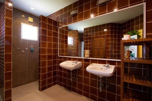 梅尔皮姆Hacienda Resort - Mae Phim的棕色瓷砖浴室设有两个水槽和镜子