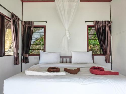 皮皮岛Phi Phi Private Beach Resort的一张带2条毛巾的白色床,窗户