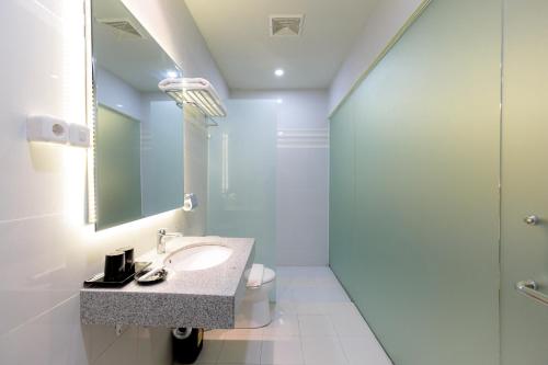 泗水Sans Hotel 88 Andalan Surabaya by RedDoorz的一间带水槽和淋浴的浴室