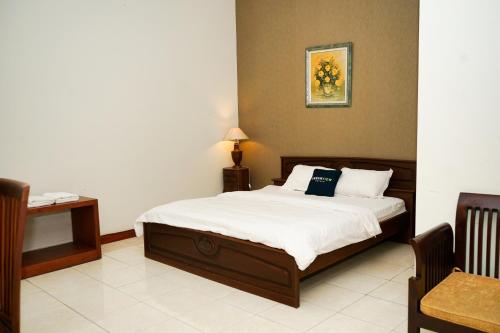 MartapuraUrbanview Hotel Ratu Elok Syariah Banjarbaru by RedDoorz的一间卧室配有一张床、一张桌子和一盏灯
