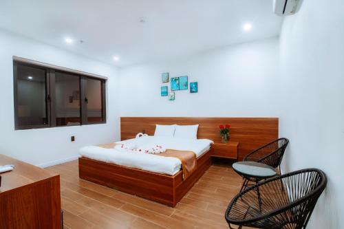 洞海Diamond Hotel Quảng Bình的卧室配有一张床和一张桌子及椅子