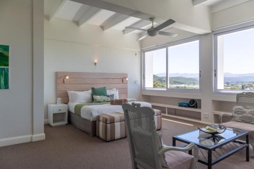 普利登堡湾Lookout Lodge的一间卧室配有一张床和一张沙发