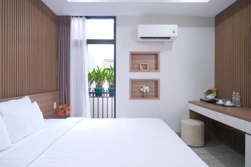 胡志明市Mother's Home的卧室设有一张白色大床和一扇窗户。