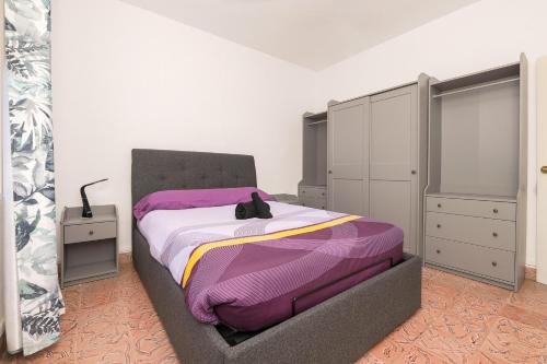 BonanzaDulce Carmen的一间卧室配有一张带紫色毯子的床