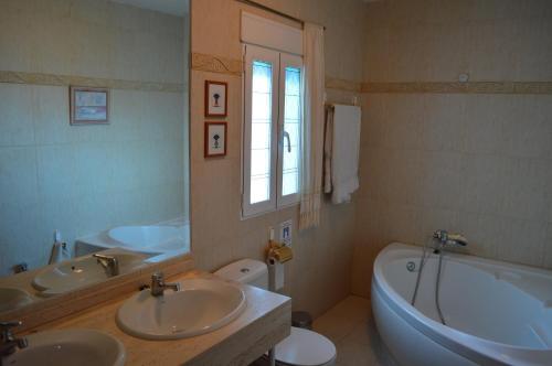 莫纳奇尔Chalet AIRAM的一间带两个盥洗盆、浴缸和卫生间的浴室