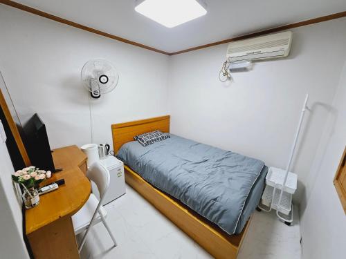 首尔K Highstel的一间小卧室,配有床、书桌和电脑