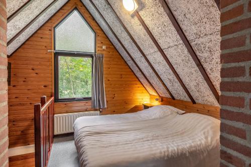 HerpenSummio Bungalowpark Herperduin的木屋内的卧室配有一张床