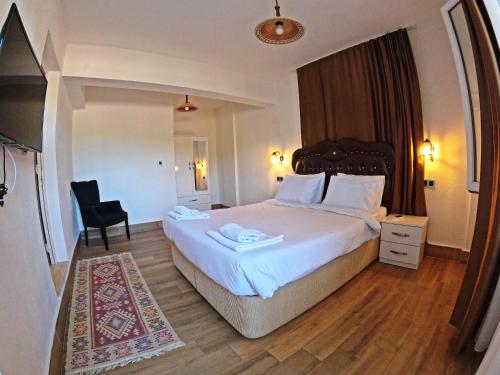 塞尔丘克Efes Hidden Garden Resort Otel的配有一张床和一把椅子的酒店客房