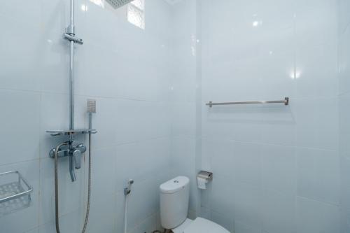 日惹Urbanview keTemon Hotel & Resto YIA by RedDoorz的带淋浴和卫生间的白色浴室