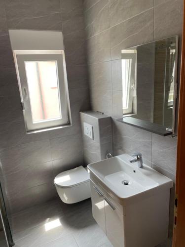 波弗加纳Apartments Vidovic的一间带卫生间、水槽和镜子的浴室