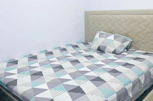 明古鲁省Pondokan Guest House Rinjani Syariah的一间卧室配有一张带 ⁇ 子毯子和枕头的床