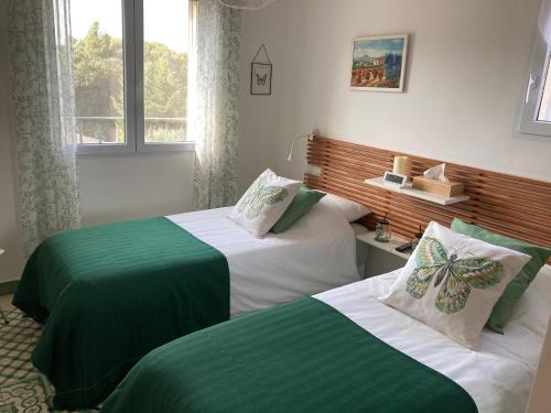 莫里埃莱阿维尼翁Domaine des Lavarines的一间卧室配有两张带绿色和白色床单的床