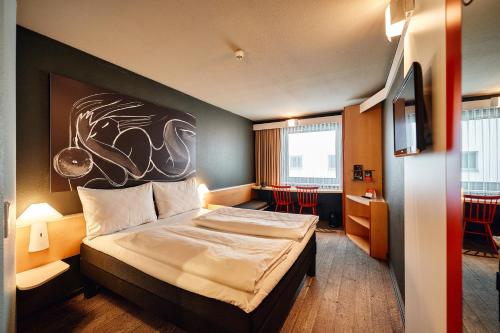 维也纳维也纳市宜必思酒店的酒店客房的墙上设有一张带绘画的床铺。