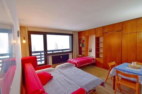 摩德纳迪-坎皮格里奥Carlo Magno Studio apartment的客厅配有红色家具和桌子
