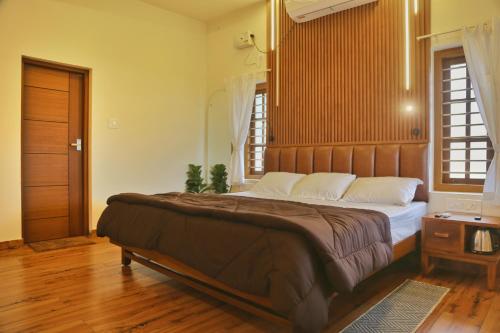 阿勒皮SHORE STORIES的一间卧室配有一张大床和木制床头板