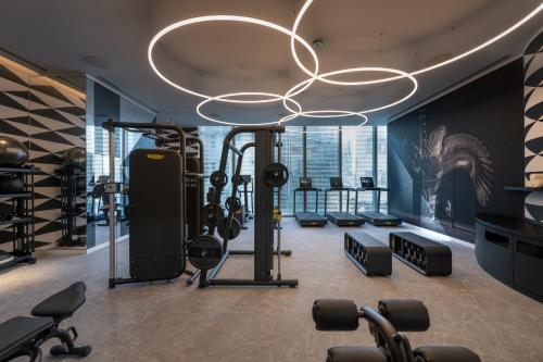 香港香港梦卓恩酒店的一间健身房,配有数台跑步机和举重器材