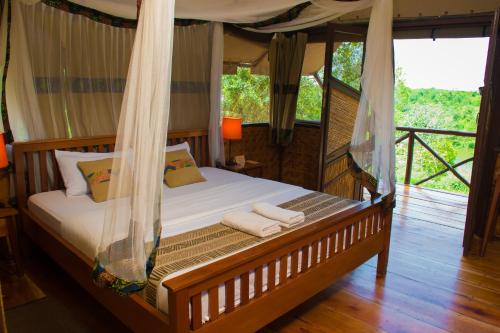 BushenyiQueen Elizabeth Bush Lodge by NATURE LODGES LTD的一间卧室配有一张带蚊帐的床