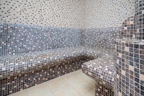 拜尔斯布龙奥登霍夫费伦酒店的瓷砖客房 - 带长凳的浴室