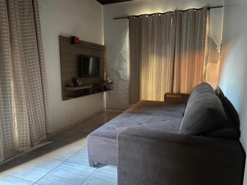 AndiráCasa de Andirá的一间卧室配有一张床、一张沙发和一台电视。