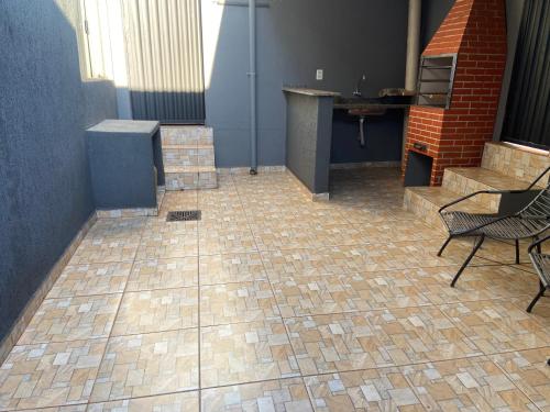 AndiráCasa de Andirá的客房铺有瓷砖地板,配有椅子和桌子。