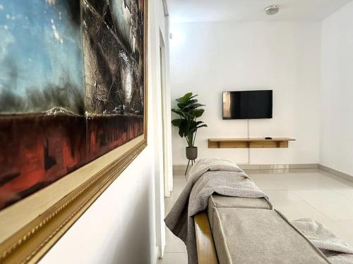 瓦加杜古Appartement - Le Grège的客厅配有沙发和墙上的绘画