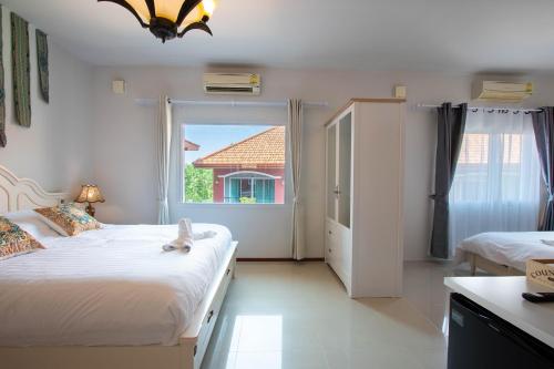 梅尔皮姆Hacienda Resort - Mae Phim的一间卧室设有两张床和窗户。