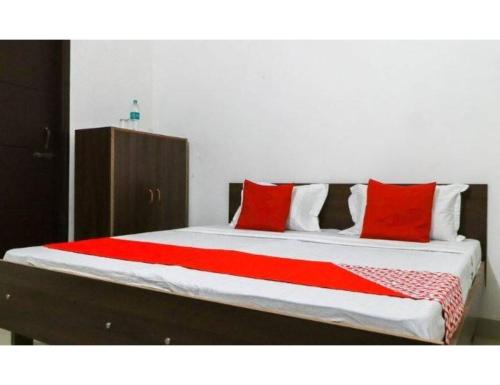 Verma Ji Hotel, Raman, Punjab的一张床上的红色枕头