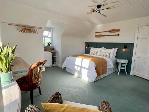 海上费萨德Thistledown Lodge的卧室配有1张床、1张桌子和1把椅子