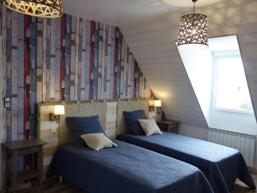 LanmodezMaison de la Presqu'île - 4 chambres avec Vue Mer的配有两张床铺的蓝色床单和墙壁
