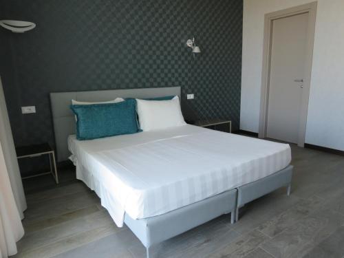 马里纳-迪-皮特拉桑塔Hotel Joseph的卧室配有带蓝色枕头的大型白色床