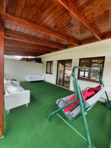 德布勒森VRG 1 Exkluzív Apartman的一间铺有绿色地毯并配有秋千的客房