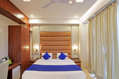 诺伊达Diamond Admire Hotel & Banquets by MMD的一间卧室配有一张带蓝色枕头的大床