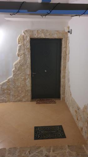 卡萨诺德莱穆尔杰MERCADANTE - Luxury Holiday House的石头墙上的黑色门,有地毯